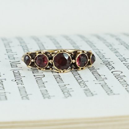 LOT:16 | A Georgian silver and gold, foil-back garnet ring, with rose-cut  diamond shoulders.